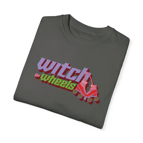 Gray t-shirt with "Witch on Wheels" text in purple and green, featuring a red roller skate graphic. The vintage-style design has a slightly faded look on a relaxed-fit unisex tee.